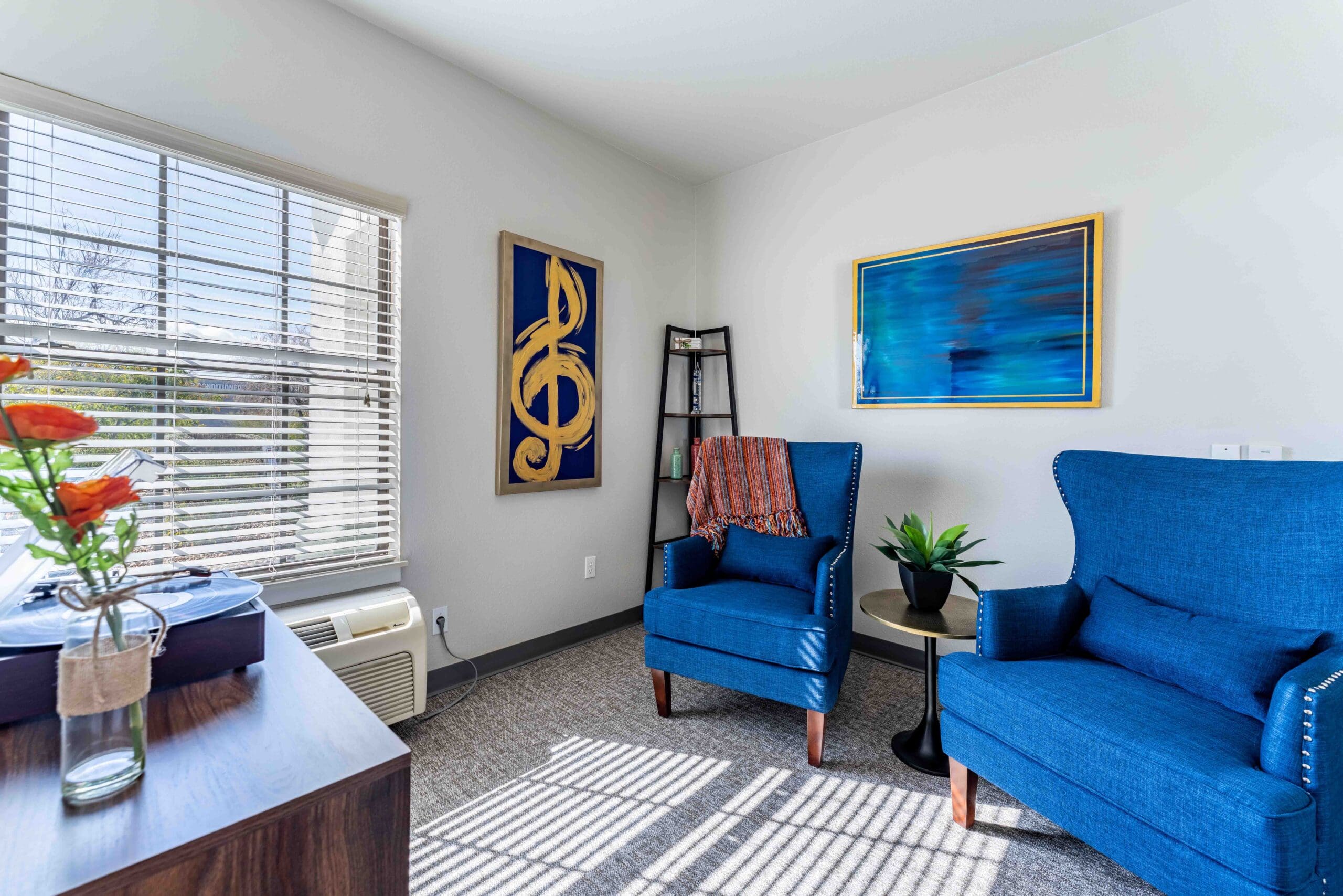 MM_Patti-Hanna_029 - Inspirations of River Centre Interior shot of a resident's living room with comfortable chairs and colorful artwork.